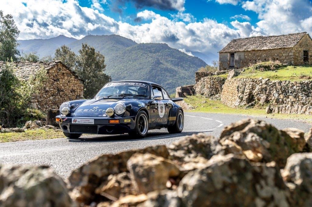 La Porsche 911 RSR 3 litres devant des bergeries de pierre, au Tour de Corse Historique