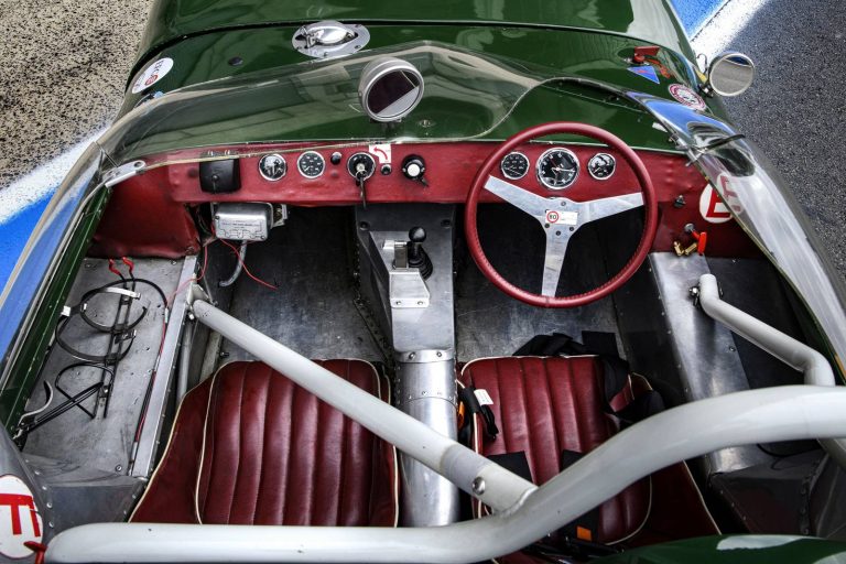 Poste de pilotage de la Lotus Eleven : volant, planche de bord et sellerie rouge