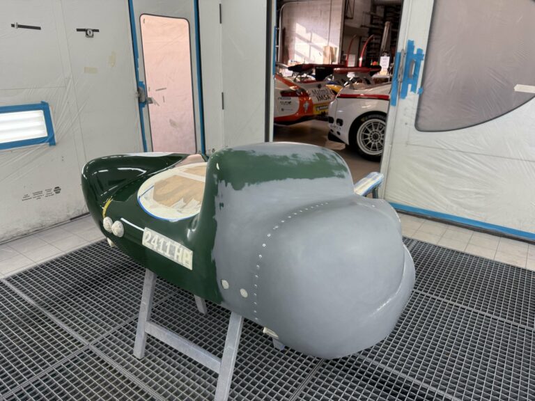 Capot arrière de la Lotus Eleven châssis 515 moitié apprêt, moitié vert anglais, sur tréteaux