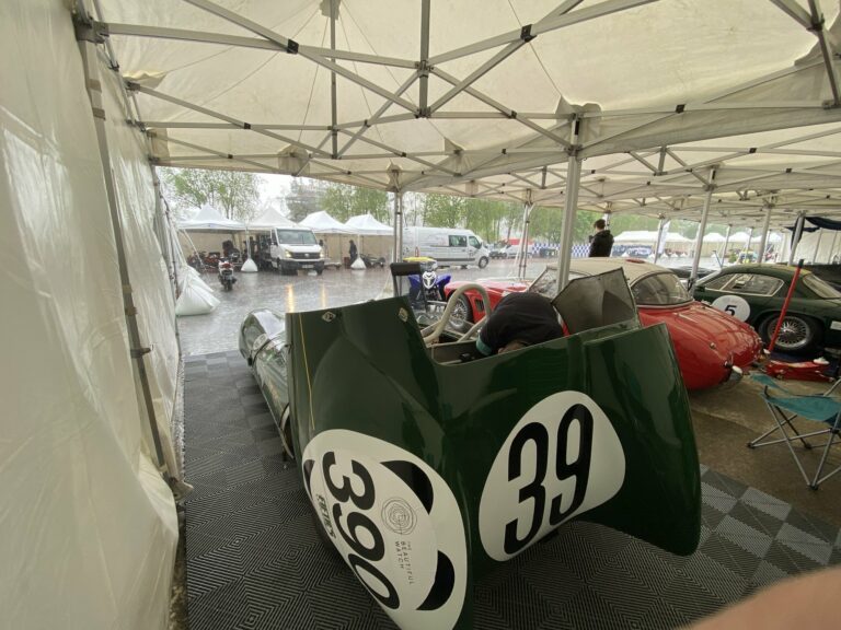 La Lotus Eleven châssis 515 dans le paddock sous la pluie, capot avant déposé