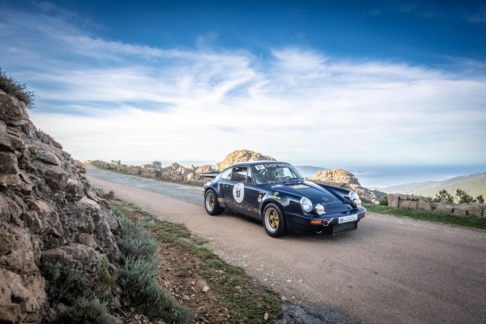Porsche 911 RSR 3 litres préparée par O-ONE sur une route de crête au-dessus de la mer, au Tour de Corse Historique