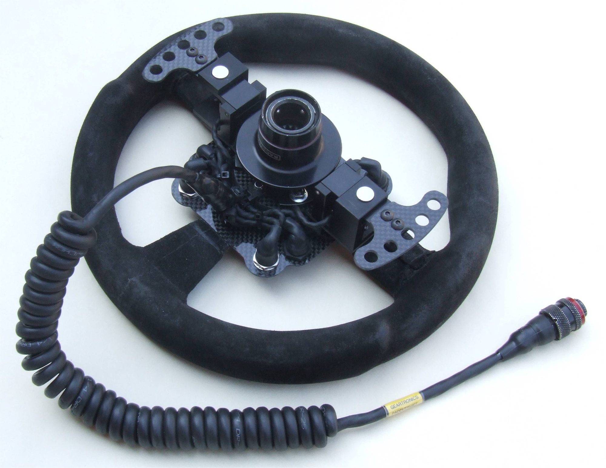 Volant de compétition équipé d'une commande de boîte au volant Geartronics, platines carbone et cordon spiralé à connecteur circulaire